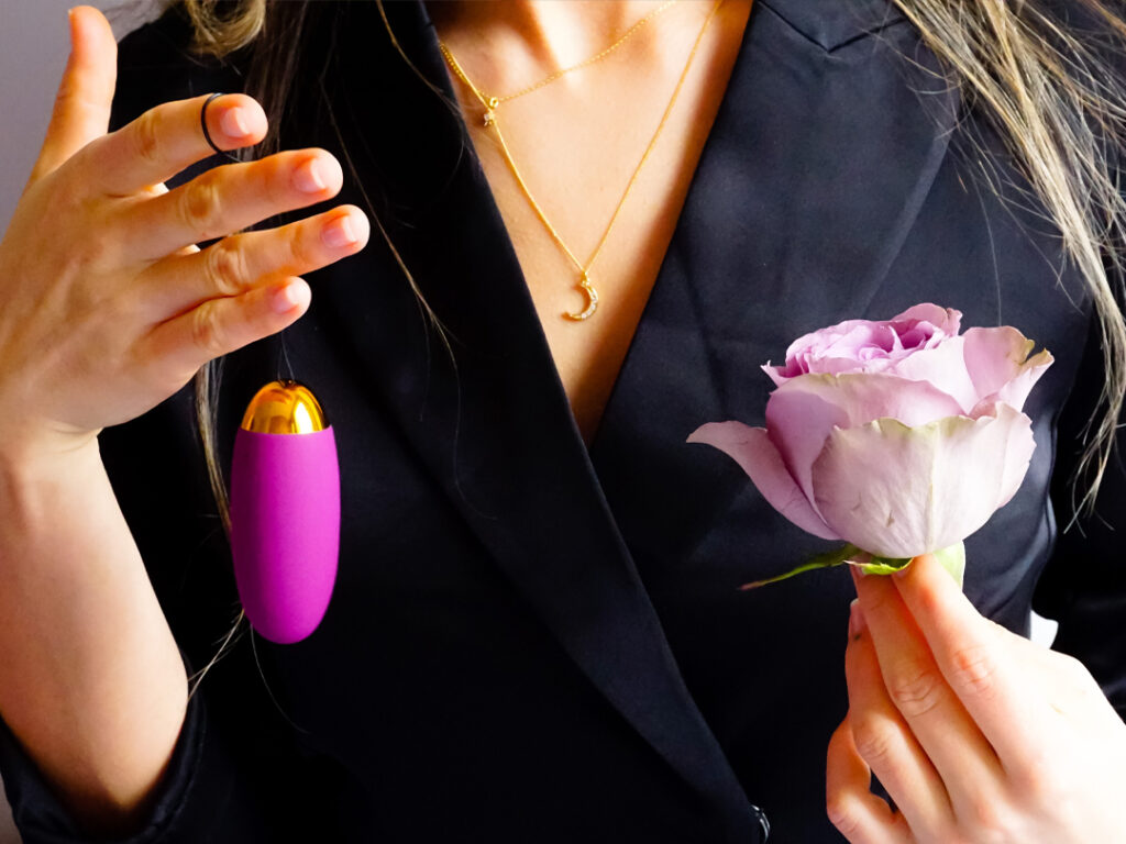 woman holding egg vibrator and rose